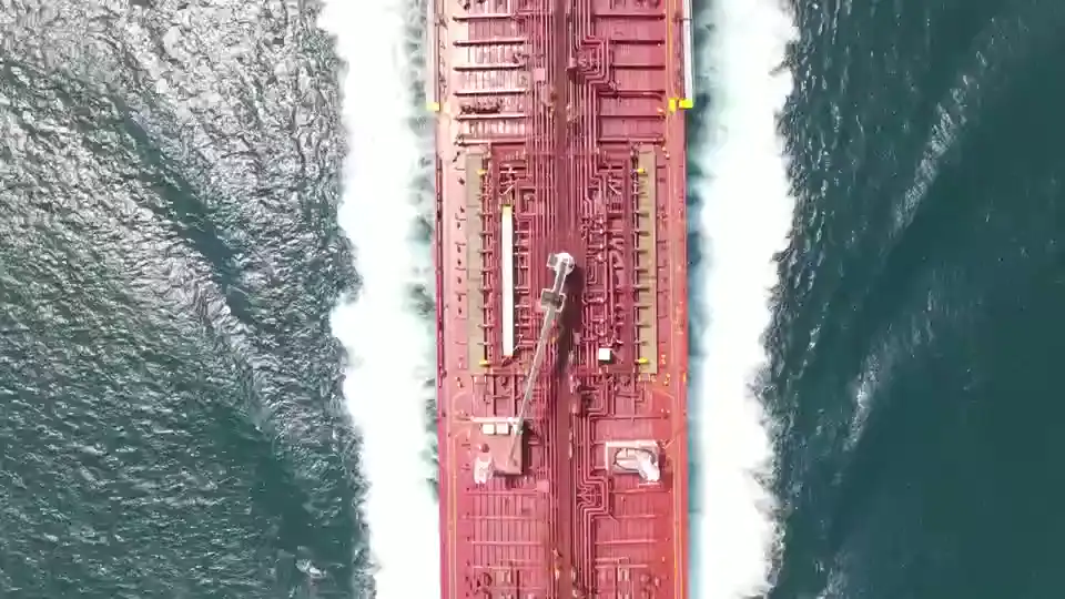 Top view of a container ship moving through open water.